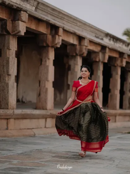 A beautiful solo portrait of the bride-to-be walking through a temple corridor, her traditional skirt in full twirl.