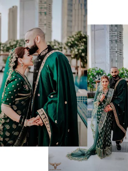 A stylish, urban-chic portrait. The groom kisses his bride's forehead against a backdrop of city skyscrapers, blending traditional attire with a modern, metropolitan vibe.