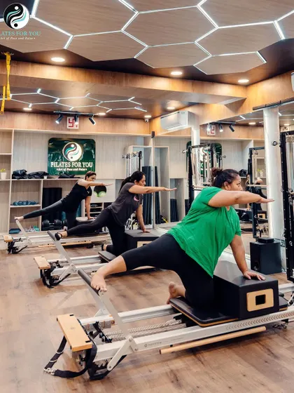 A kneeling side arm exercise that targets the obliques and shoulders. The clients demonstrate balance and control, key principles of the Pilates method.
