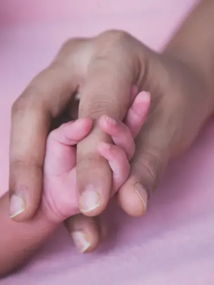 One of the most powerful images: a newborn's tiny hand wrapped around their parent's finger, symbolizing trust and connection.