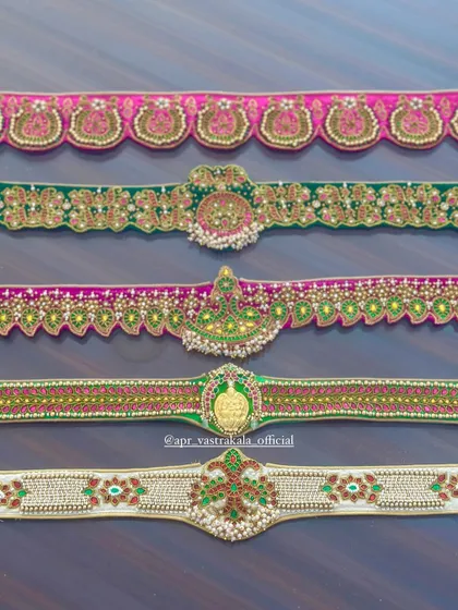 A top-down view of the collection of embroidered waist belts, showing the variety of designs.