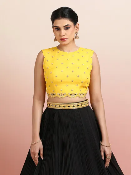 Another close-up of the yellow blouse with the black lehenga, focusing on the elegant neckline and embellishments.