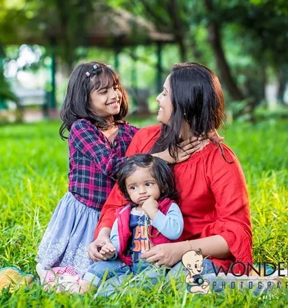 A mother enjoying a beautiful day in the park with her two children. The genuine smiles and relaxed atmosphere make this a perfect example of a natural family photoshoot.