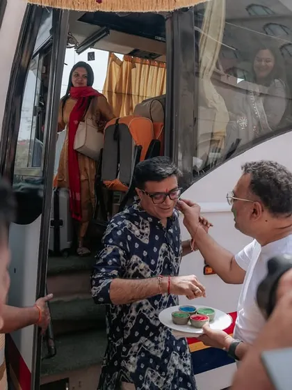 A guest arriving by bus is greeted with a traditional and colorful welcome. We manage logistics and hospitality for destination weddings seamlessly.