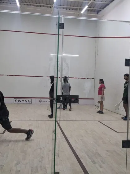 Players practicing lunges and movement on the court during a squash open house. Proper footwork is a fundamental skill we emphasize in all our training programs.