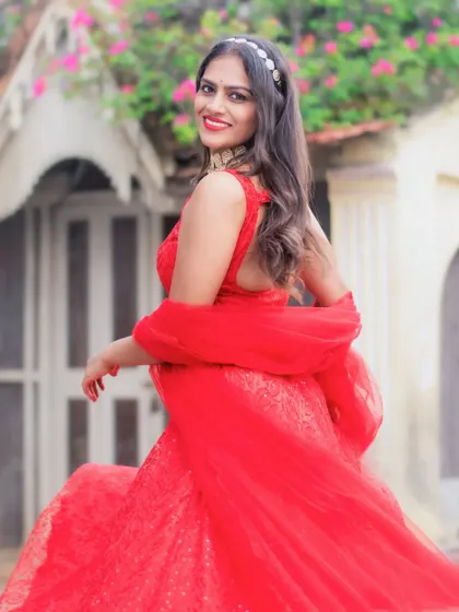 A happy, twirling shot of a model in a bright red lehenga, showing how the skirt moves.