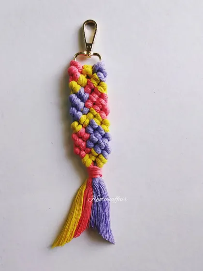 This macrame fishtail keychain in lavender, coral, and yellow is a pretty accessory that can also be used as a bag charm. It's a great option for a bridesmaid gift or party favor.