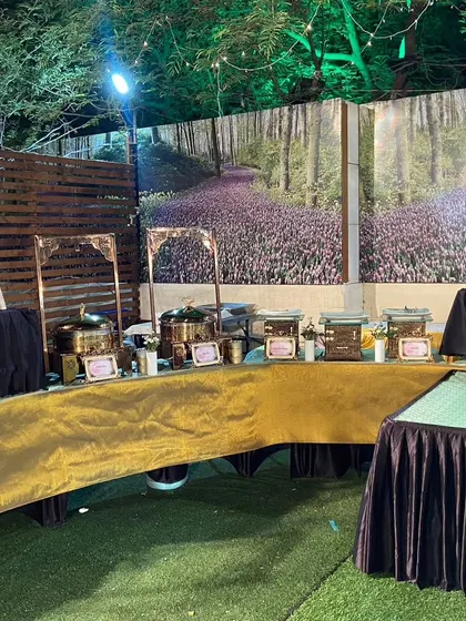 A beautiful buffet arrangement against a scenic forest backdrop. This setup is perfect for themed events, blending our culinary offerings with immersive decor.