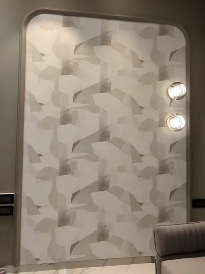 An abstract geometric wallpaper installed in a tall, curved niche. The pattern is perfectly aligned despite the challenging shape of the wall.