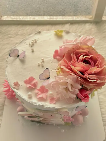 A top view of the bunny-themed baby shower cake, showing the beautiful fresh flower and butterfly arrangement.
