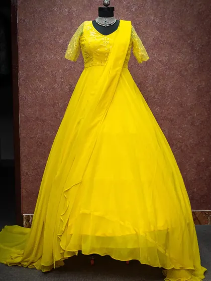 A bright and cheerful yellow gown with a trailing skirt. This is a popular choice for Haldi ceremonies or sunny outdoor maternity shoots.