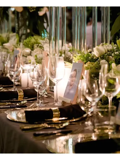 A detailed shot of the elegant black and gold table setting, complete with personalized photo place cards for a unique and intimate touch.