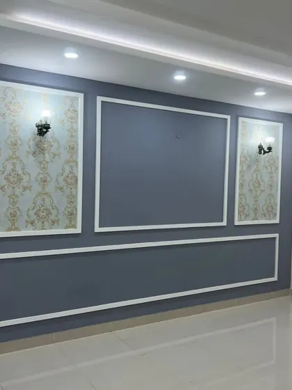 A detailed look at the accent wall, featuring classic wallpaper panels within elegant white moulding. This showcases our attention to detail in creating sophisticated wall treatments.