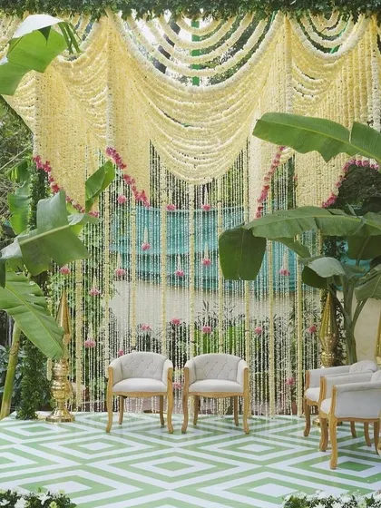 A closer view of the South Indian inspired decor with a jasmine curtain and modern seating.