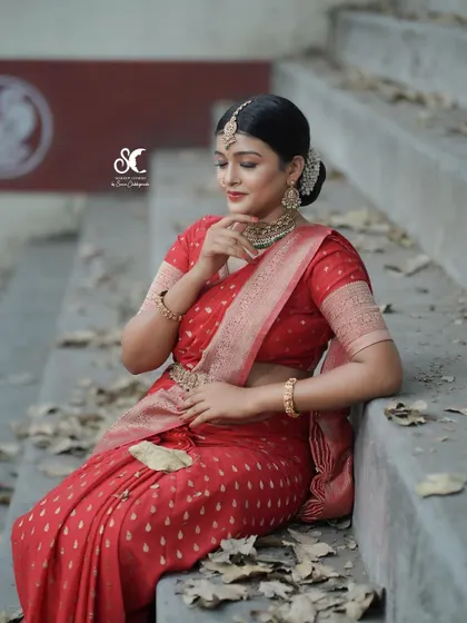 A beautiful portrait demonstrating a Sabyasachi-inspired semi-bridal look. The outdoor setting with fallen leaves adds a rustic and artistic touch to this makeup portfolio shoot.