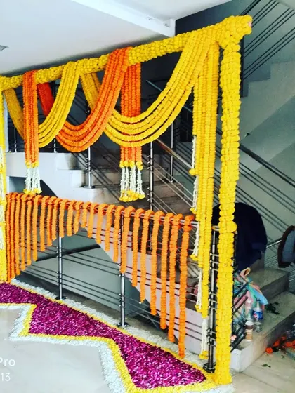 A staircase decorated with traditional marigold strings. This is a simple yet very effective way to bring the festive spirit inside the house for a Haldi or Pooja ceremony.