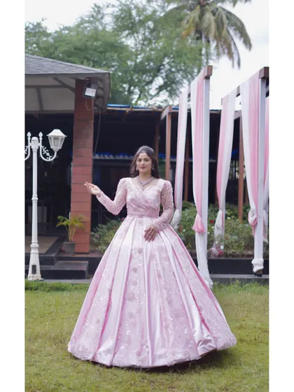 A full view of the princess-style pink gown in an outdoor setting. Its voluminous skirt and intricate detailing make it a dream outfit for any grand celebration.