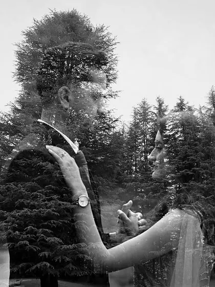 A creative double exposure, merging a portrait of the couple with the texture of the pine forest, symbolizing their deep connection to each other and to nature.