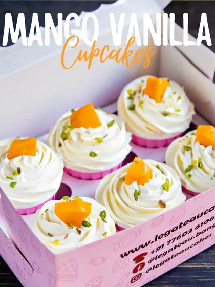 A box of our fluffy Mango Vanilla Cupcakes. These light cupcakes are topped with a swirl of fresh cream and a piece of ripe mango, perfect for any summer gathering.