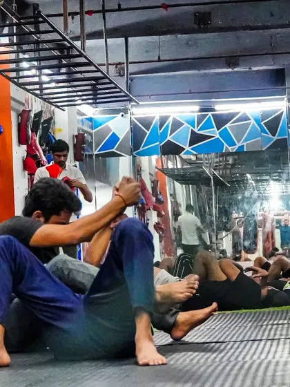 Two members practice BJJ techniques on the mat. Our ground game sessions focus on live drilling to build practical skills and muscle memory.