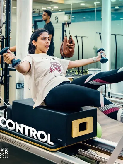 Using dumbbells for added resistance, this client performs a challenging oblique twist. This exercise sculpts the waistline and builds rotational strength in the core.