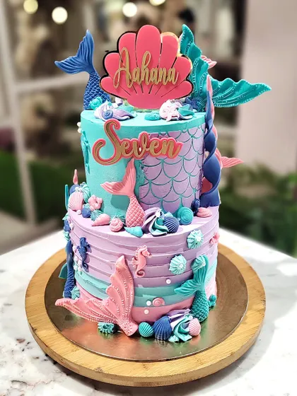 Dive into a magical underwater world with this two-tier mermaid cake. I used shades of teal, purple, and pink buttercream, and adorned it with detailed fondant mermaid tails, seashells, and seahorses.