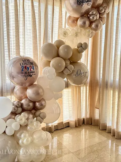 A closer look at the personalized details. We can add custom text to balloons, like the "We're expecting 2024 to be a great year" message for this baby announcement.