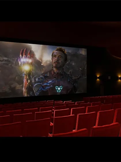 The red-seated multiplex showing a screening of 'Avengers: Endgame'. The large, curved screen helps to immerse the entire audience in the action.