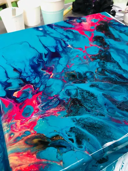 Another stunning result from a fluid art workshop. The vibrant blues and pinks create a dynamic and energetic piece.