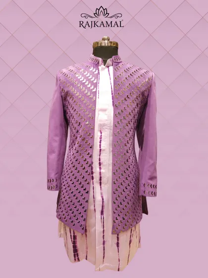 A modern Indo-Western outfit in a vibrant purple, featuring a jacket with geometric cut-out details and a tie-dye inner kurta.