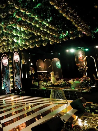 This perspective showcases the dynamic interplay of the geometric dance floor, the lush ceiling installation, and the arched, illuminated backdrops. The design creates a sense of depth and grandeur, perfect for a high-energy Sangeet night.