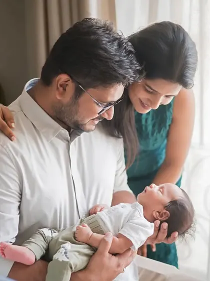 A moment of quiet admiration. The new parents gaze lovingly at their newborn by the window, the soft natural light creating a beautiful, gentle scene.