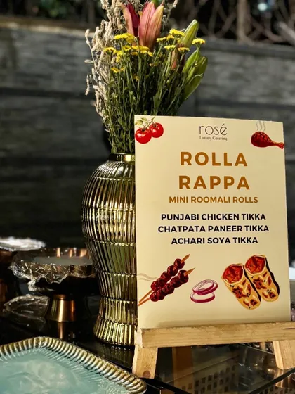 The menu for our "Rolla Rappa" station, featuring a variety of mini roomali rolls. We offer fillings like Punjabi Chicken Tikka and Chatpata Paneer Tikka, catering to both vegetarian and non-vegetarian preferences.