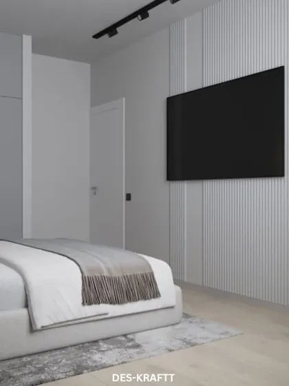 The view towards the entrance highlights the minimalist design, with a full-length fluted panel wall concealing the wardrobe for a seamless finish.