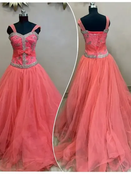 This peach-colored ball gown features a silver-beaded corset-style bodice with a small bow detail. The back laces up for a perfect fit.