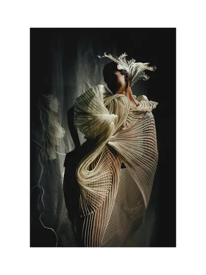 A high-contrast, artistic shot for Vaishali S. The play of light and shadow almost abstracts the model's form, focusing entirely on the unique, flowing lines of the white couture gown.