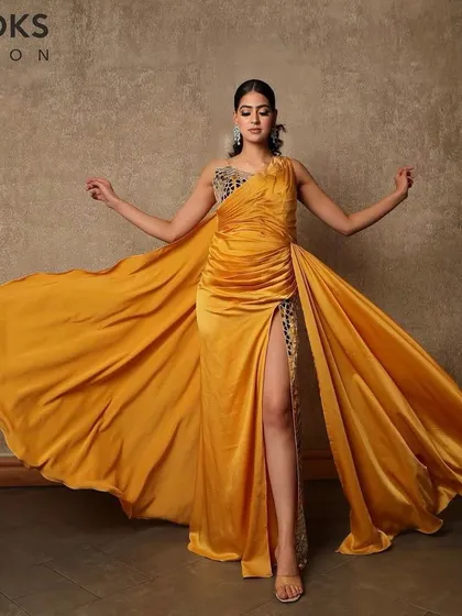 A dramatic full-length pose showing off a complete evening look. The makeup is bold enough to stand out, complementing the flowing yellow gown and ensuring our client is ready for her grand entrance.