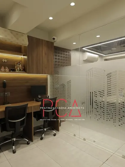 The main workstation area at StyleIn Homes, with custom desks, overhead storage, and frosted glass partitions for a semi-private yet collaborative environment.