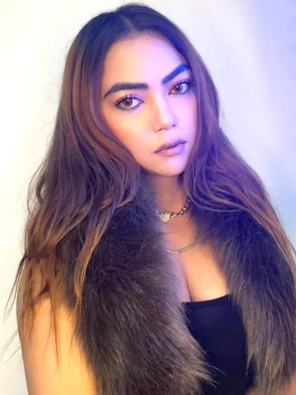 A close-up portrait showing off a stylish look with a faux fur collar.