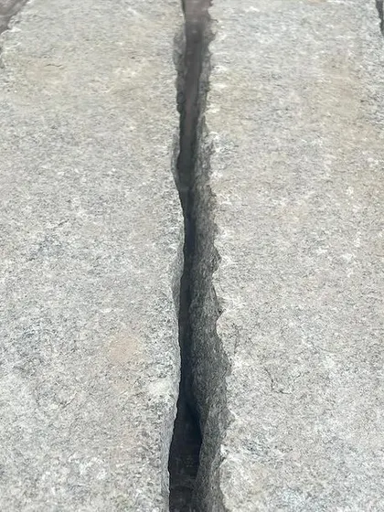 The natural, uncut edges of thick stone slabs.