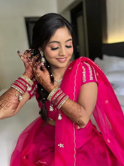 A close-up of the bride getting ready, showing her beautiful bangles and soft makeup.