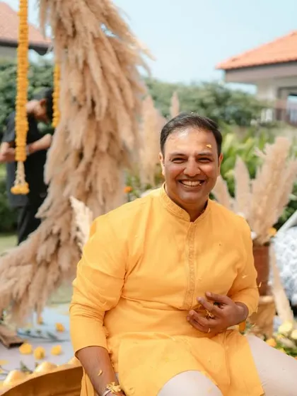 A smiling portrait of the groom, seated and ready for the Haldi rituals to begin.