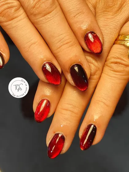 A vibrant red cat-eye manicure with a dark, vampy twist. The magnetic effect creates a beautiful gradient from bright red to deep burgundy.