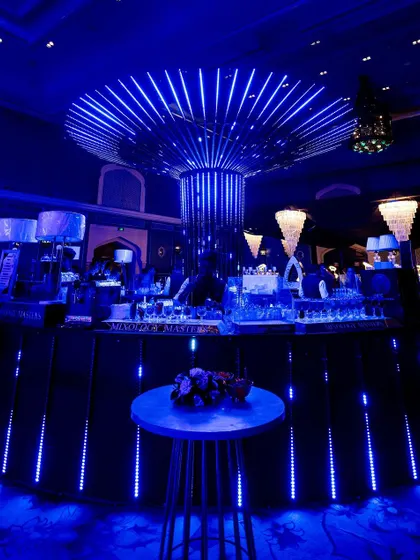 The central bar, glowing with blue LED lights, serves as a vibrant hub for the Sangeet party.