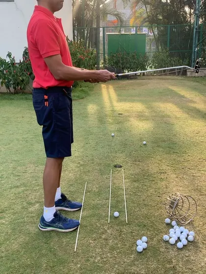A side view of a putting lesson, showing the student's posture and the setup of the drill. Building a solid foundation in putting is key to lowering scores.