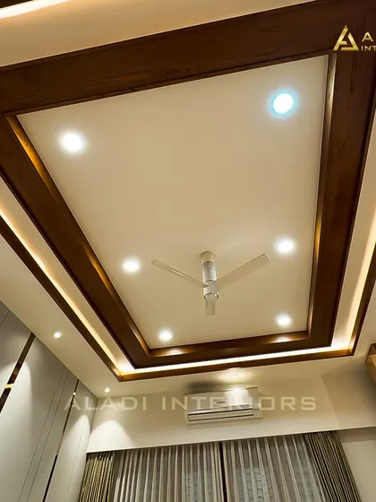 A view of a sophisticated false ceiling design with a recessed wooden frame and integrated cove lighting. This architectural detail adds depth and warmth to the room.