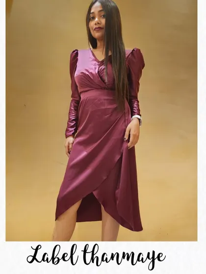 A stylish bodycon dress in a wine color. The wrap-style front and puffed sleeves make it a modern choice for a party.