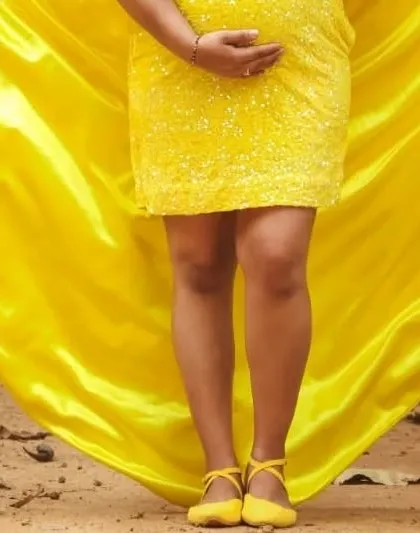 A detail shot of the yellow bodycon maternity dress and matching shoes.