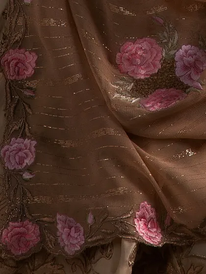 A detail of the organza dupatta, adorned with 3D floral embroidery in shades of pink, adding a delicate and romantic touch to the bridal lehenga.
