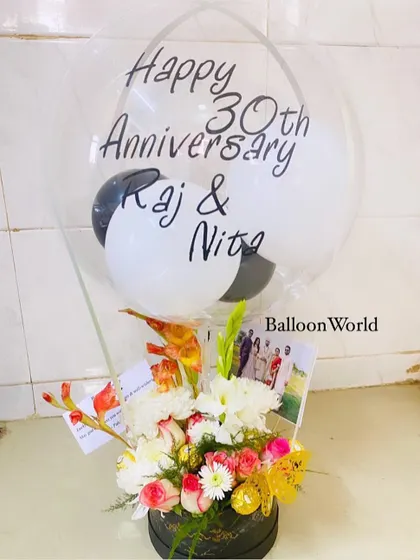 A 30th anniversary is a milestone worth celebrating. This hamper includes a custom balloon with the couple's names, a fresh flower arrangement, and personal photos tucked into the bouquet.